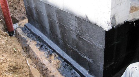 Exterior foundation recently excavated with dirt pushed to sides