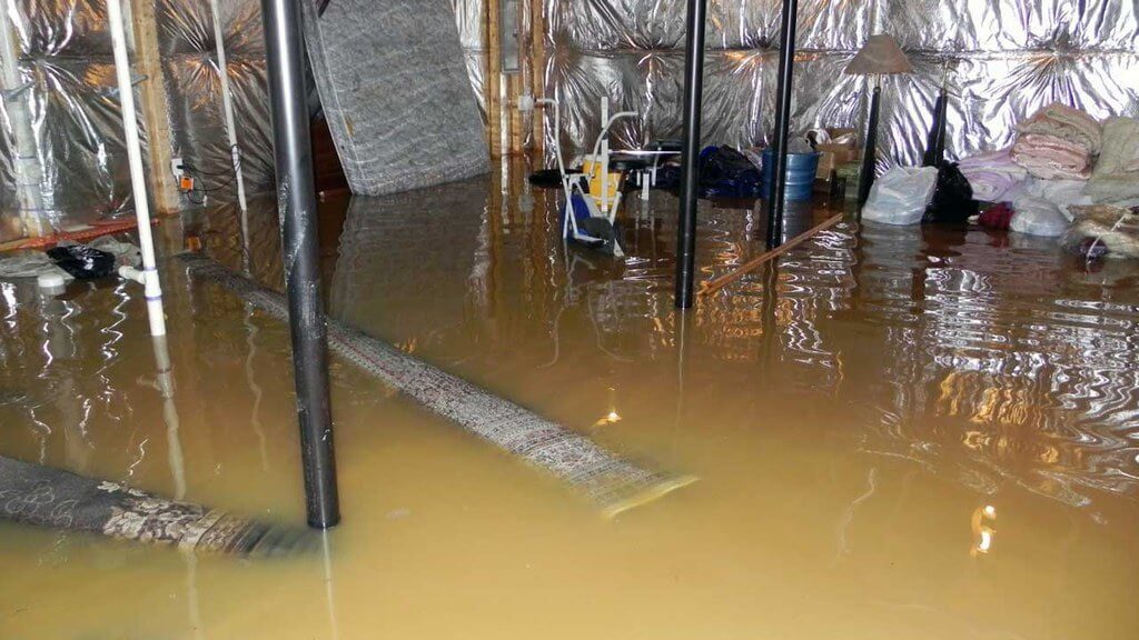 Basement severely flooded with rolls of carpets floating in the water