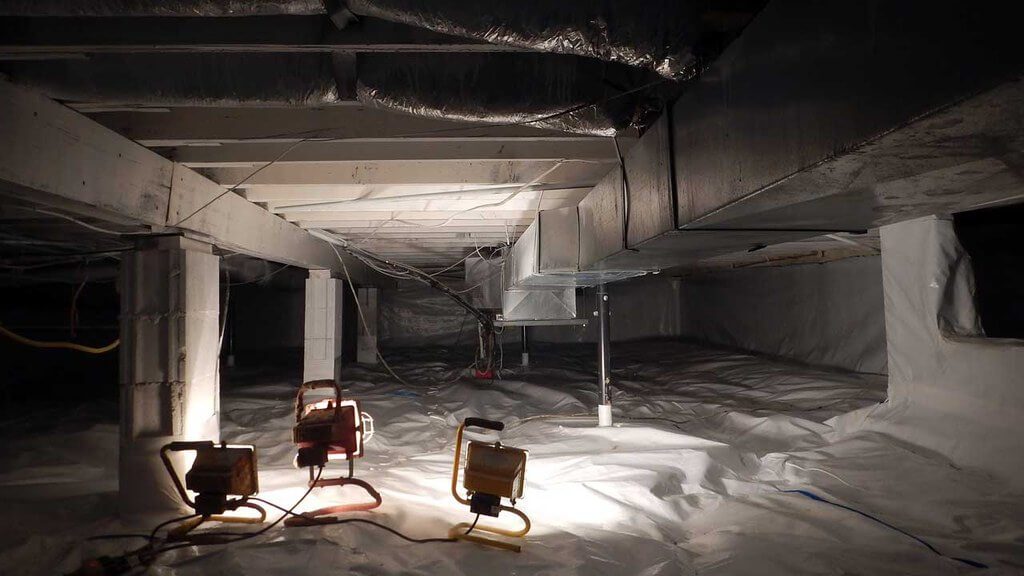 Industrial lights being shined on crawl space area that is insulated