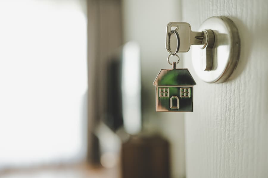 Key opening the door of a new home