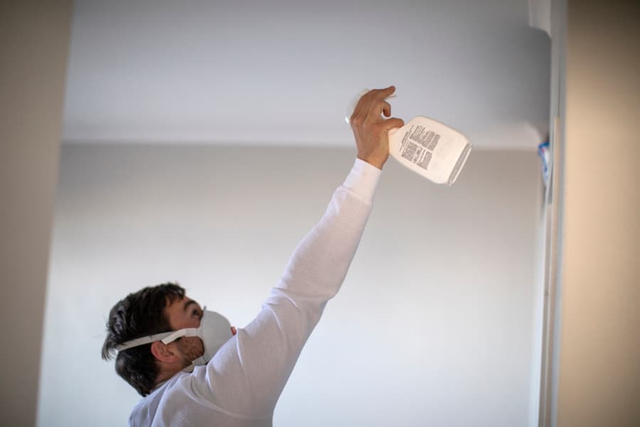 Homeowner wearing personal protective gear to remove mold from house