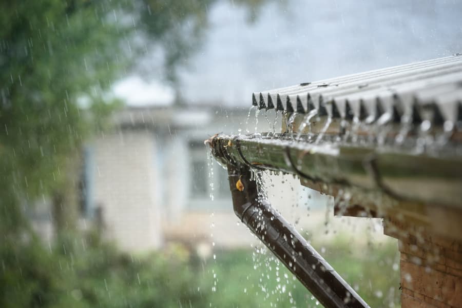 Rain flows down from a roof down