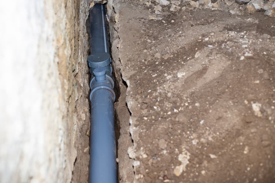 Drainage pipe in hole in ground removing wastewater from house