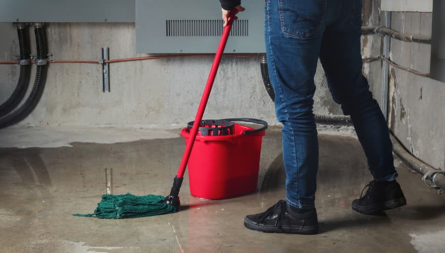 Mopping puddles in flooded basement