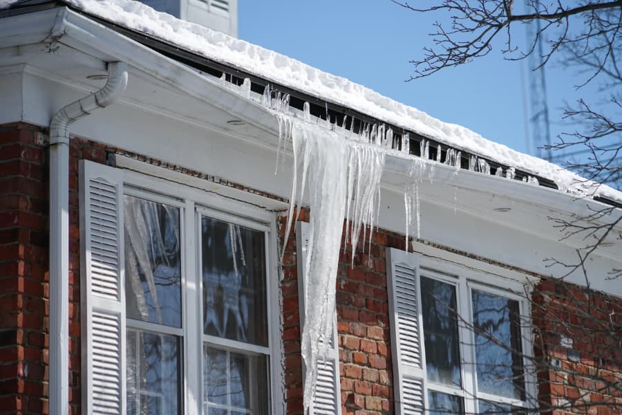 Freezing icicles hanging from gutter of home