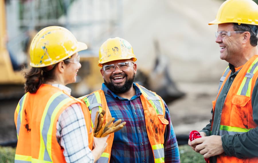 Three construction contractors smiling and chatting
